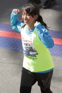 Teenage girl passes the finish line of a marathon