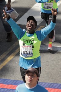 Joyous black teenager crosses finish line