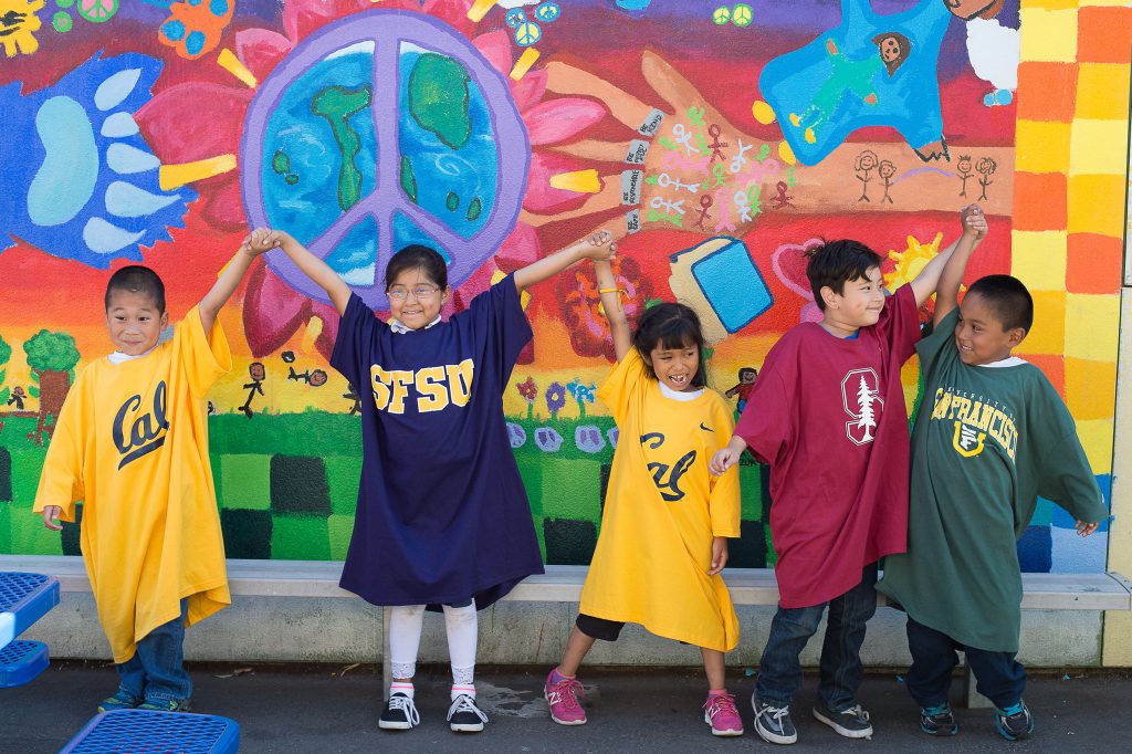 Small children wearing large college t-shirts