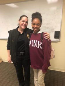 A smiling policewoman poses with a smiling Kennrod student