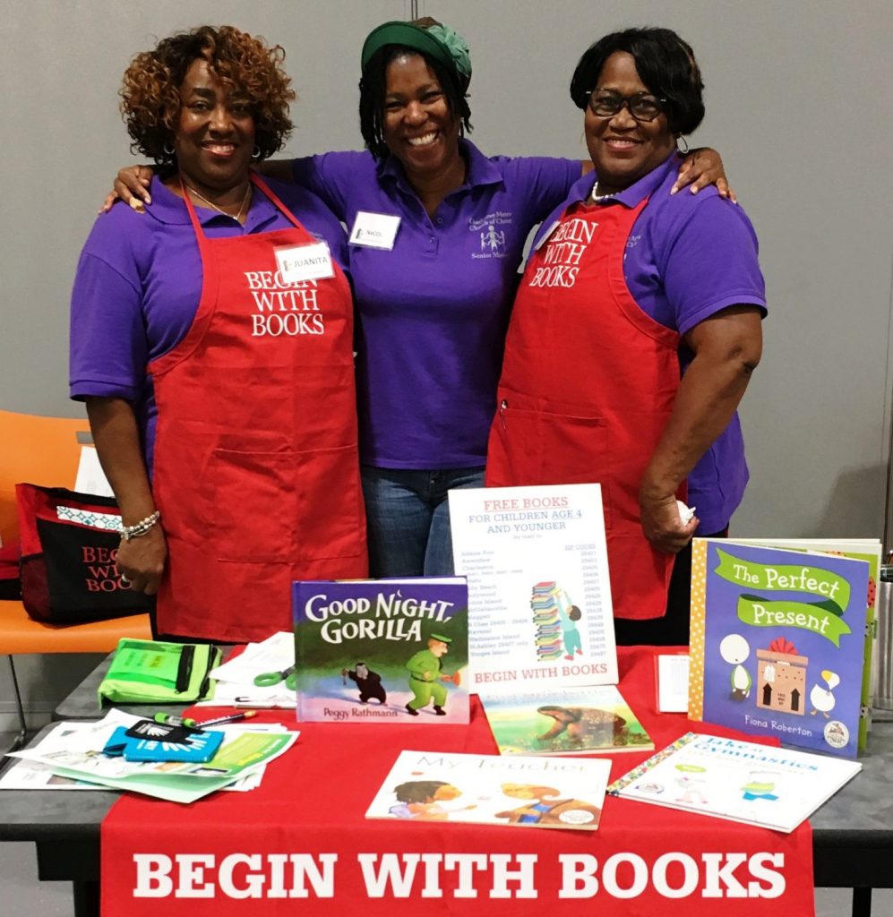 Three smiling BEGIN WITH BOOKS volunteers