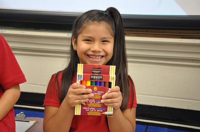 Happy girl holds up new markers