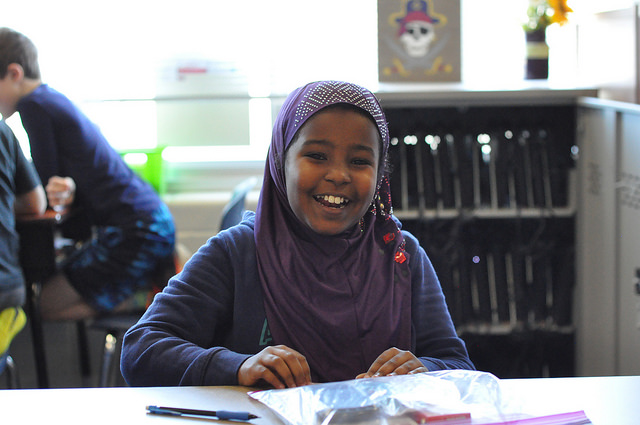 Girl in hijab is happy to receive school supplies