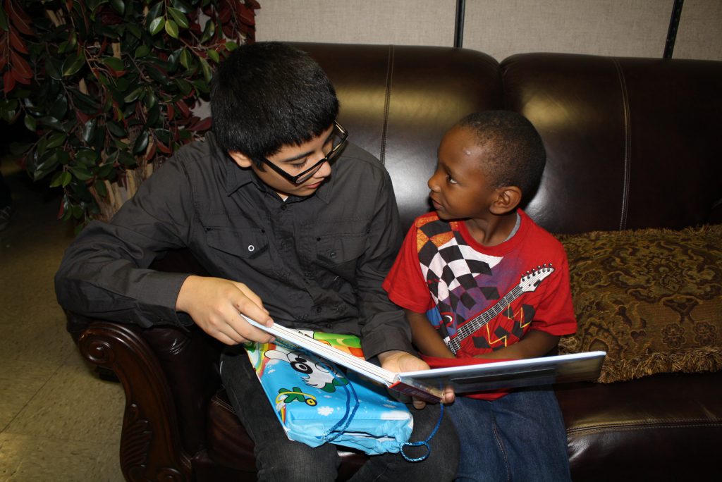 Older boy reads to younger boy