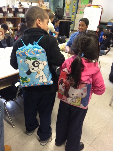 Two children show off their new backpacks