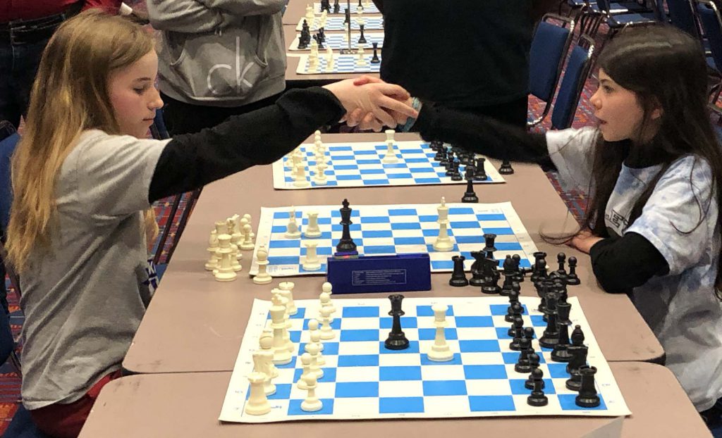 Girls shake hands during chess tournament