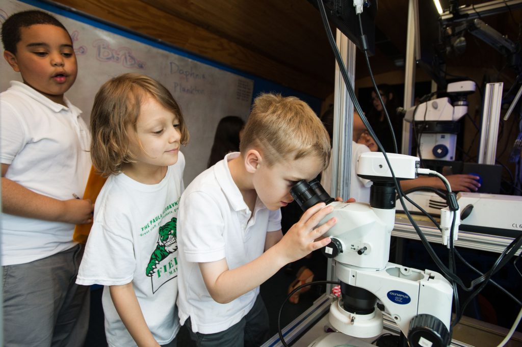 Taking turns looking into a microscope aboard BioBus