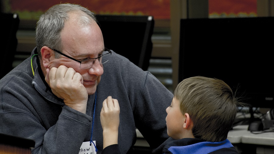 Small boy tells CLC tutor about the item he is holding in his hand