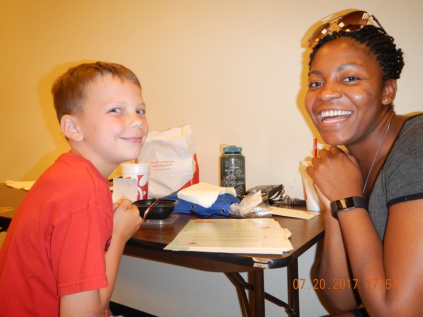 Smiling blond boy with laughing CLC tutor