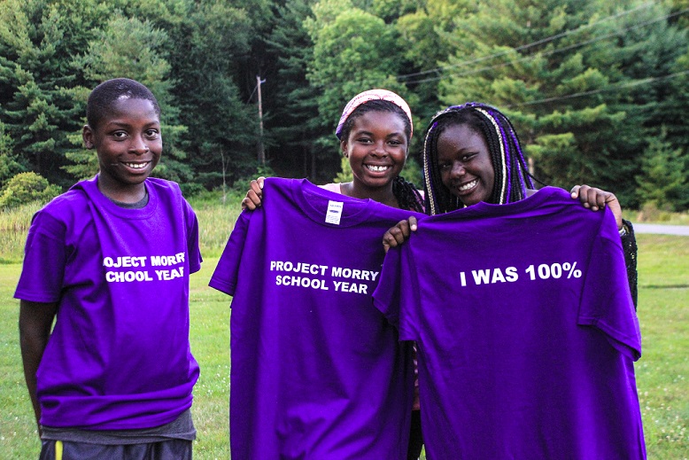 Project Morry Participants holding up t-shirts associated with success