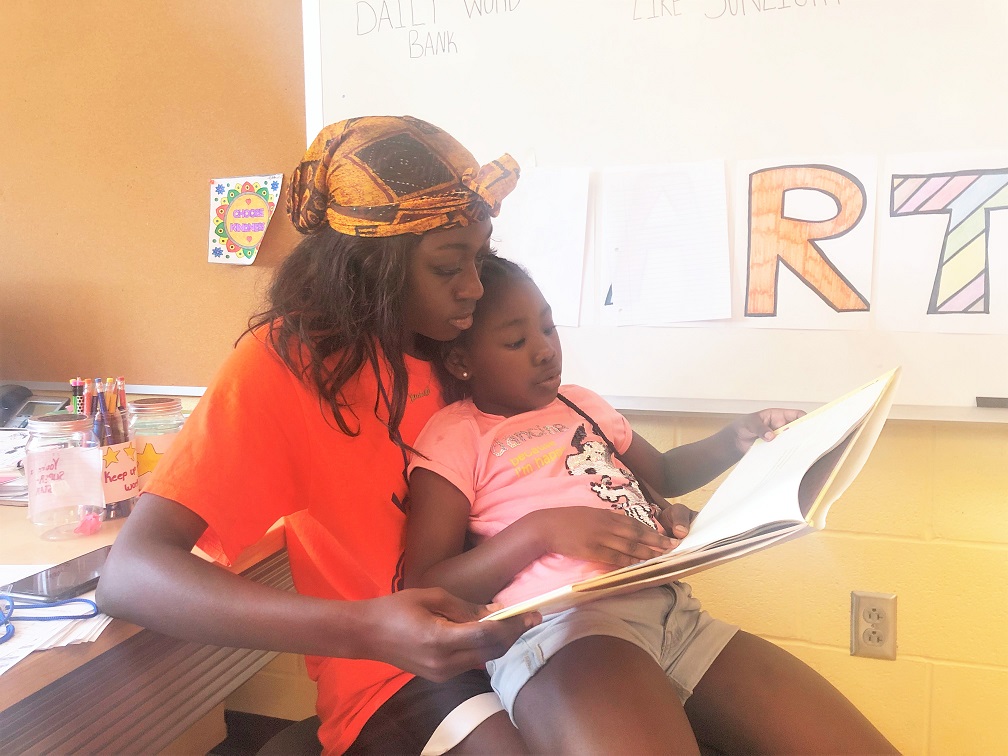 LEAP mentor reading and cuddling with her LEAP mentee