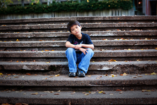 boy sits alone on steps