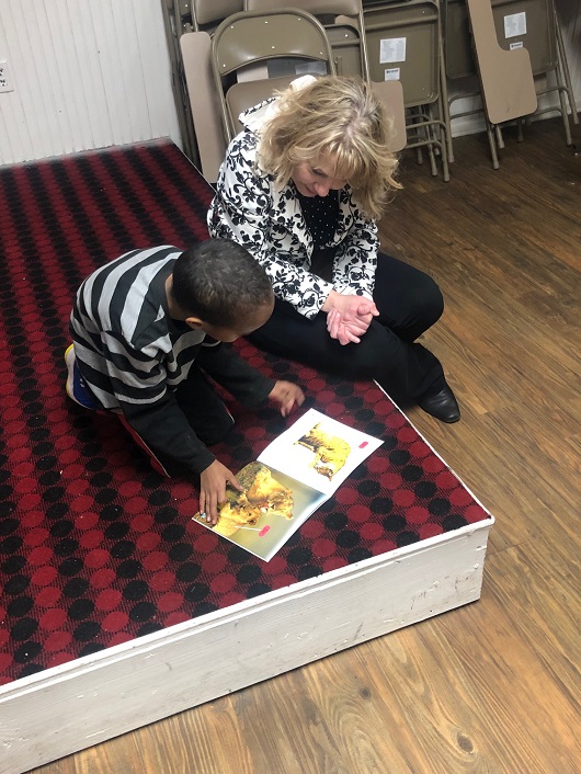 Volunteer helps young PFSS student with his reading