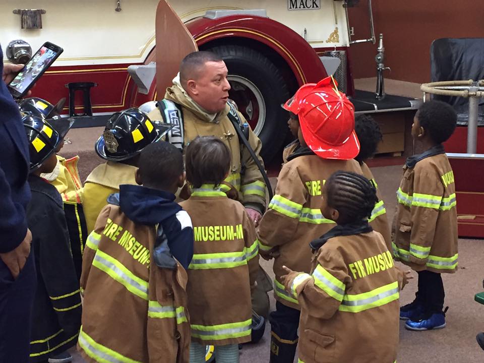 Firefighter Chuck talks about fighting fires with a group of school children