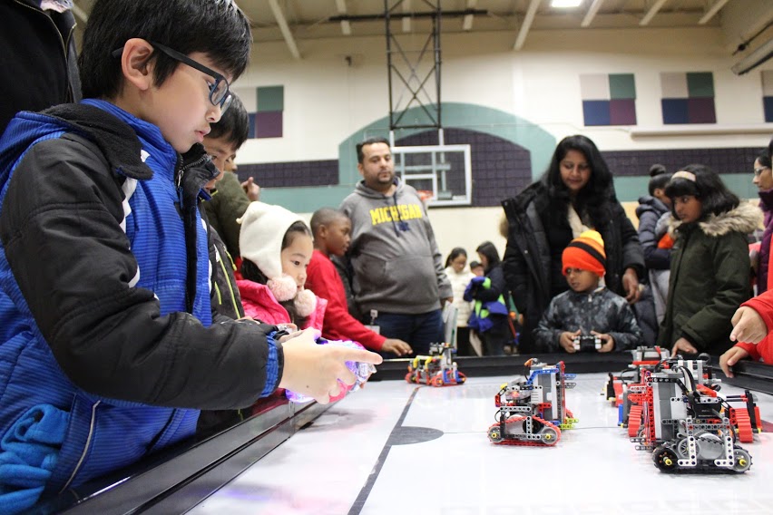 young boy races homemade robot during a STEM Night