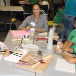 Smiling TSCC staff member works with children at table