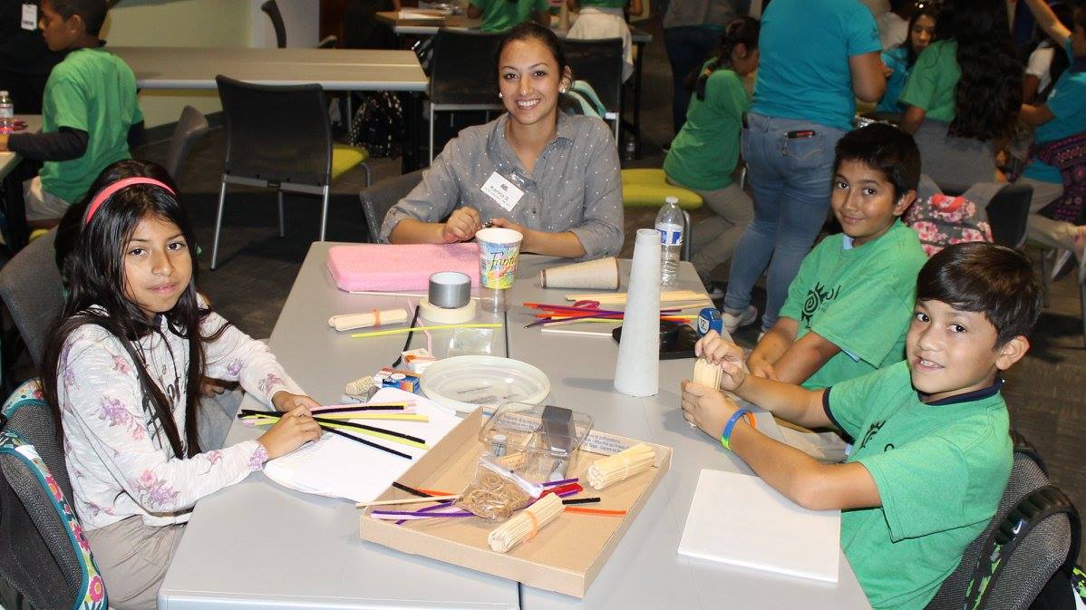 Smiling TSCC staff member works with children at table