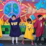 Small children wearing large college t-shirts