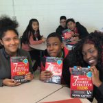 High school students smile on receiving book about the habits of success