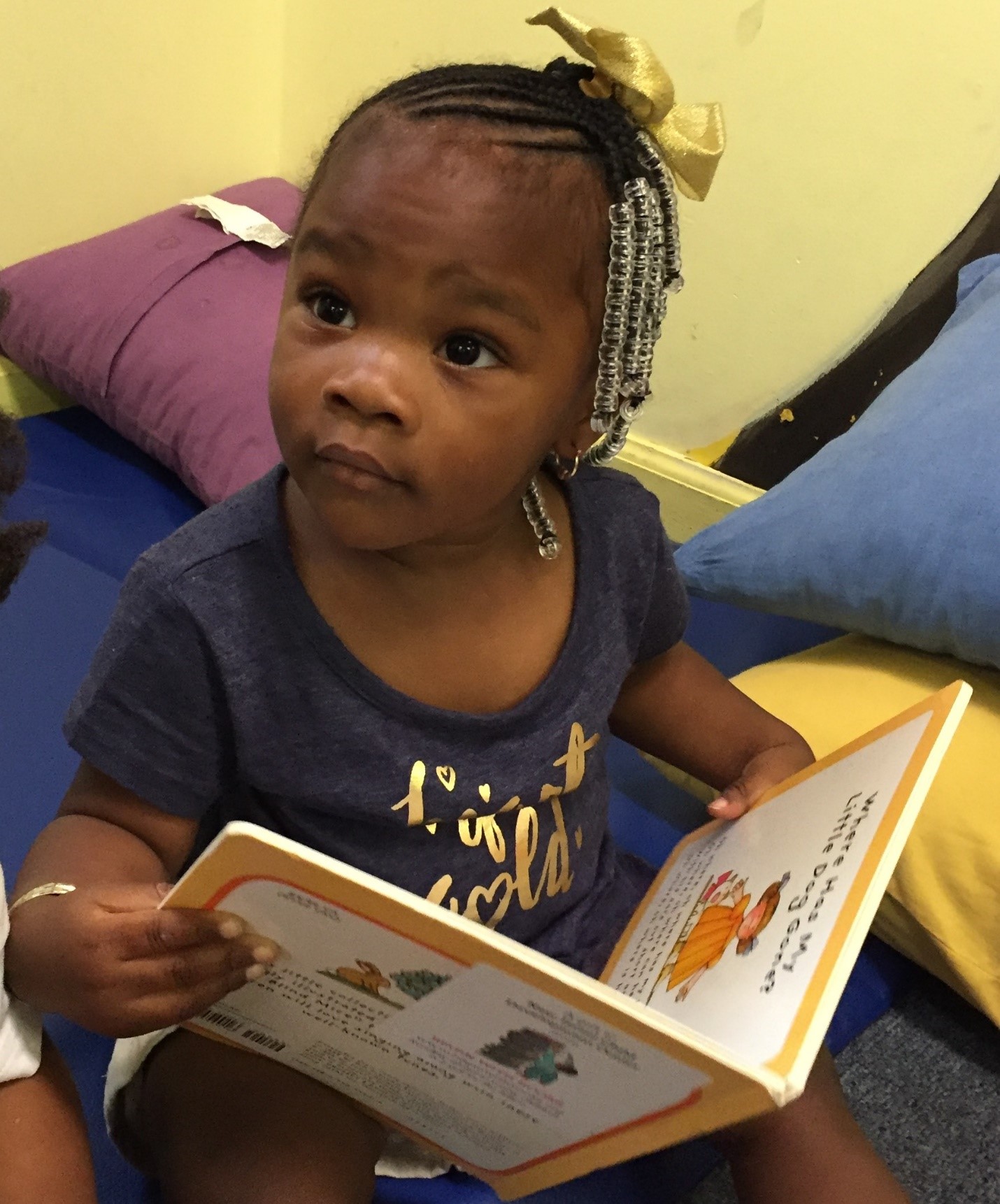 Toddler holds open storybook