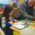 SMART volunteer listens to young girl read