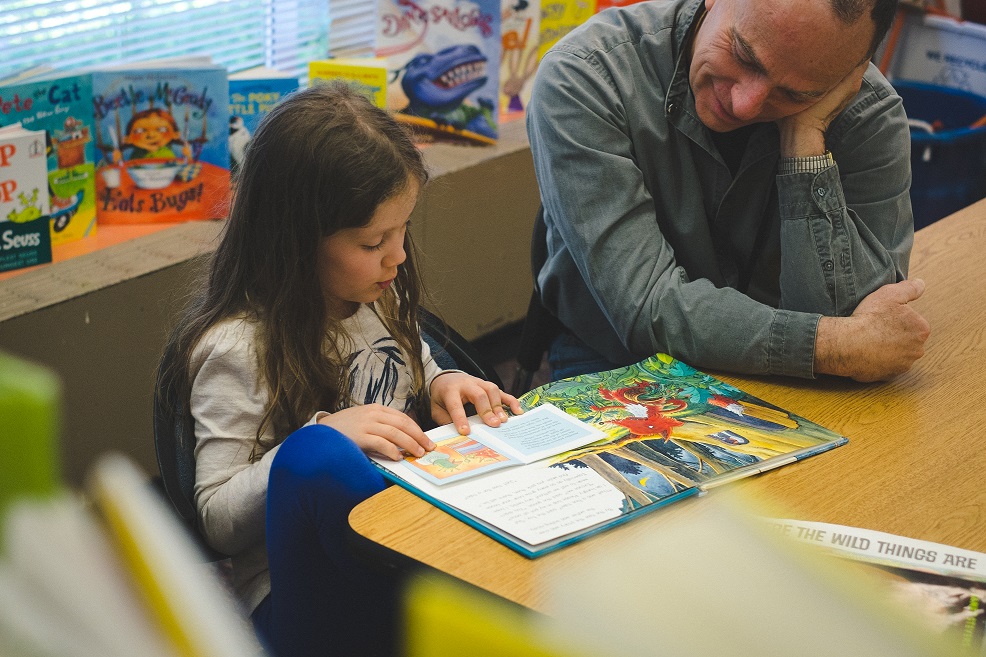 SMART volunteer listens to young girl read