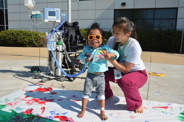 Smiling young patient with Ranken Jordan volunteer