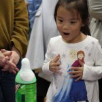 Girl looks on in wonder at homemade volcano
