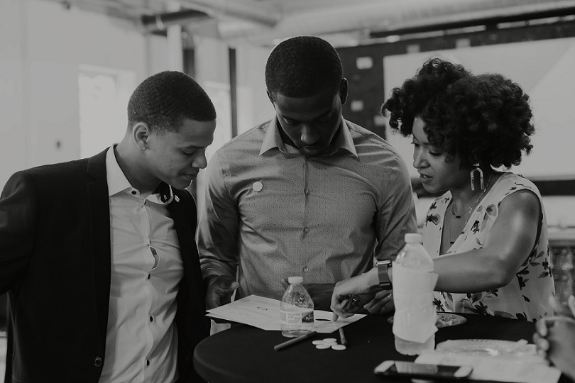 black and white photo of Gray Matter participants working with CEO