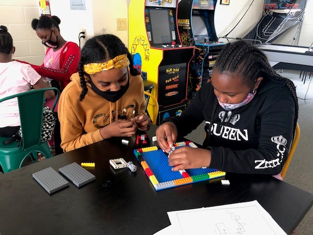 Female Urban Scholars Academy participants build with lego in the after school Homework Club