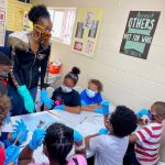 Urban Scholars Academy teacher works with students in the classroom