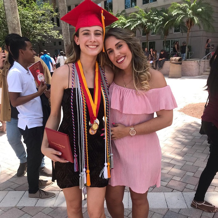 happy female graduate with sister