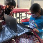 Boy and girl collaborate on homework over laptop at Mid-Peninsula Boys & Girls Club