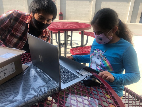 Boy and girl collaborate on homework over laptop at Mid-Peninsula Boys & Girls Club