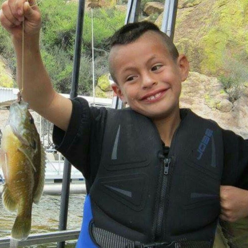 Smiling Arizona Outdoor Adventures participant holds a fish he caught, his first