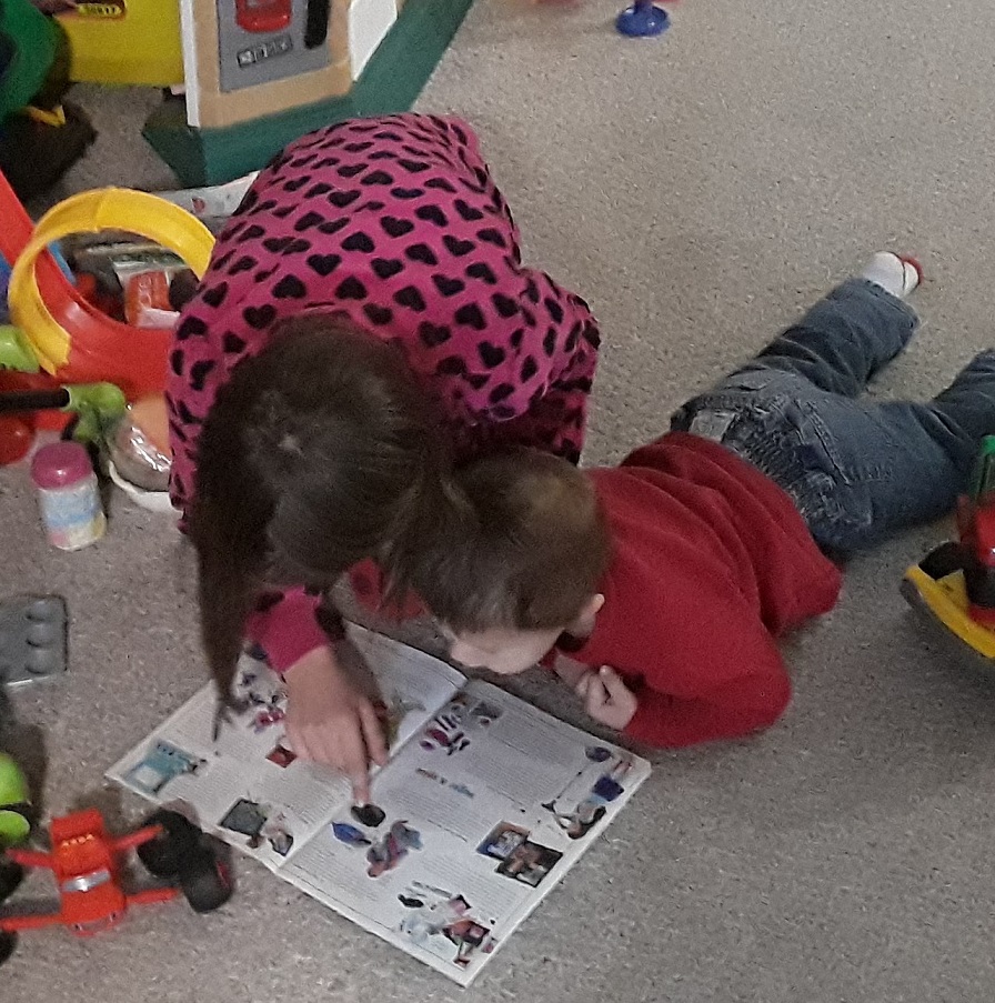 Madeline reads to a younger child via the Life Tools Foundation