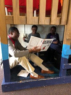 Male volunteer reads to two children, Everybody Wins! Atlanta