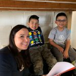 Young woman reads to two hispanic children for Everybody Wins! Atlanta