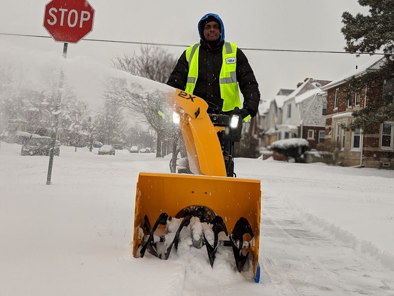 Participant in The Lawn Academy clears snow for seniors