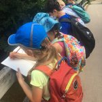 Urban Adventure Squad children write what they learn on a field trip out of doors in DC