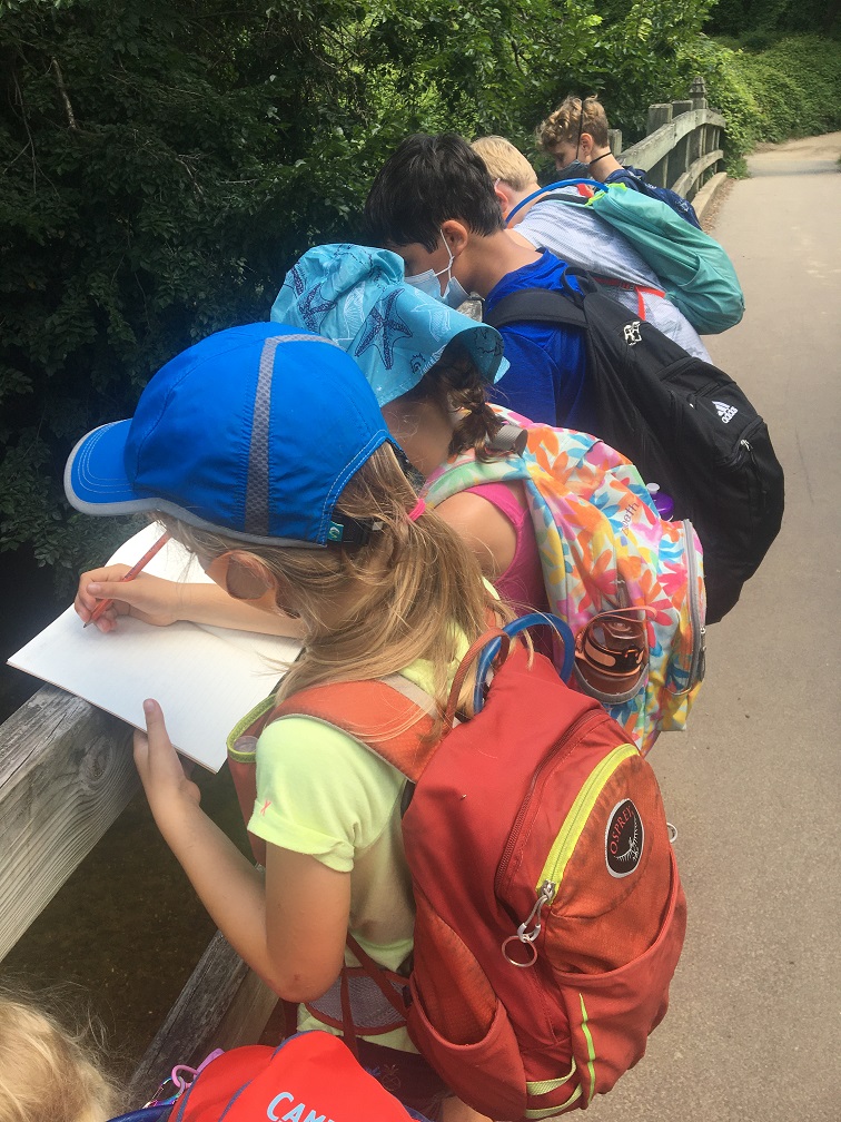 Urban Adventure Squad children write what they learn on a field trip out of doors in DC