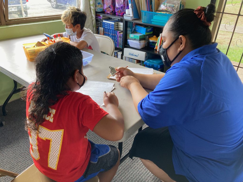 volunteer tutors young girl at Hawaii Literacy