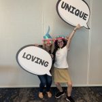 Big Sisters of Boston holding signs "unique" and "loving"