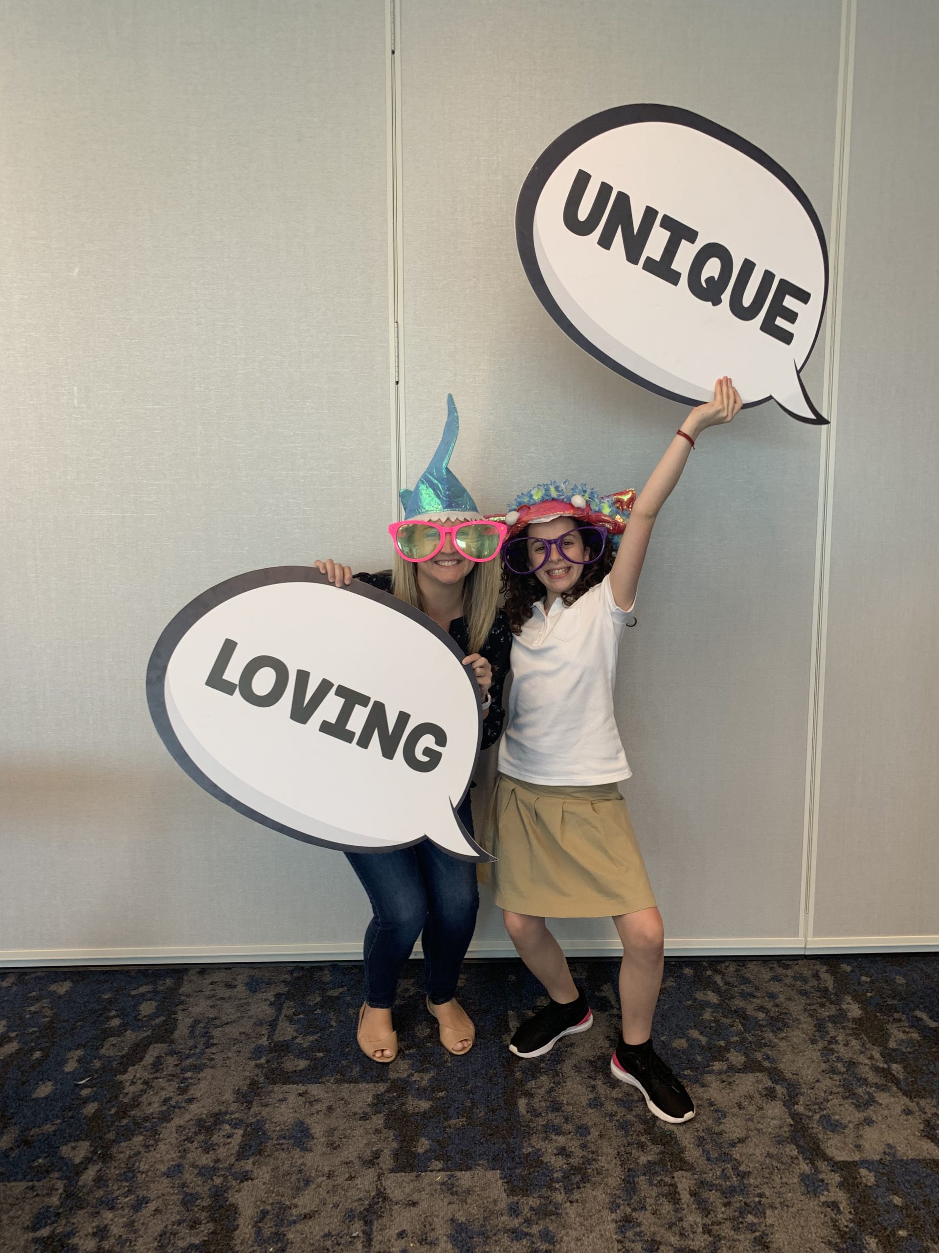 Big Sisters of Boston holding signs "unique" and "loving"