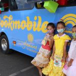 Three girls in front of Hawaii Literacy bookmobile