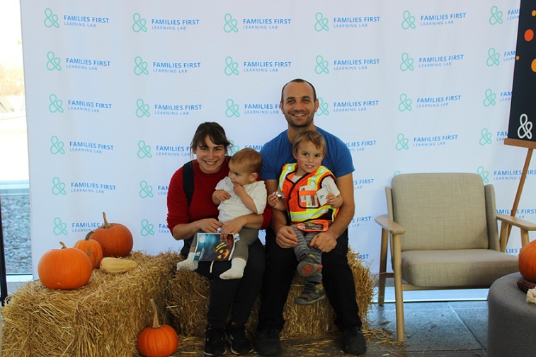 Family poses at pumpkin patch stall