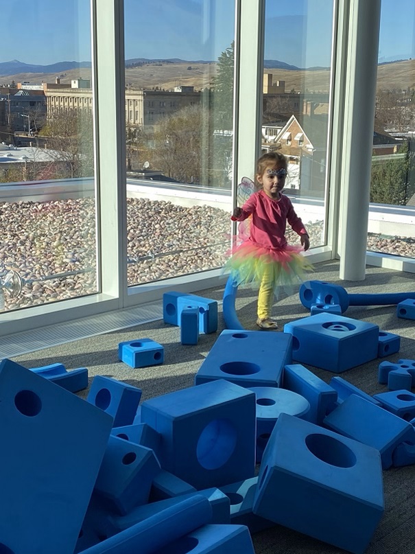 Girl climbs on blue sponge building blocks