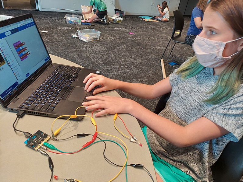 A young girl learns to code at the Bakken Museum