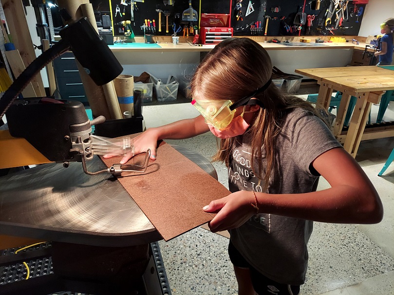 Girl uses tools in a Makerspace at The Bakken Museum