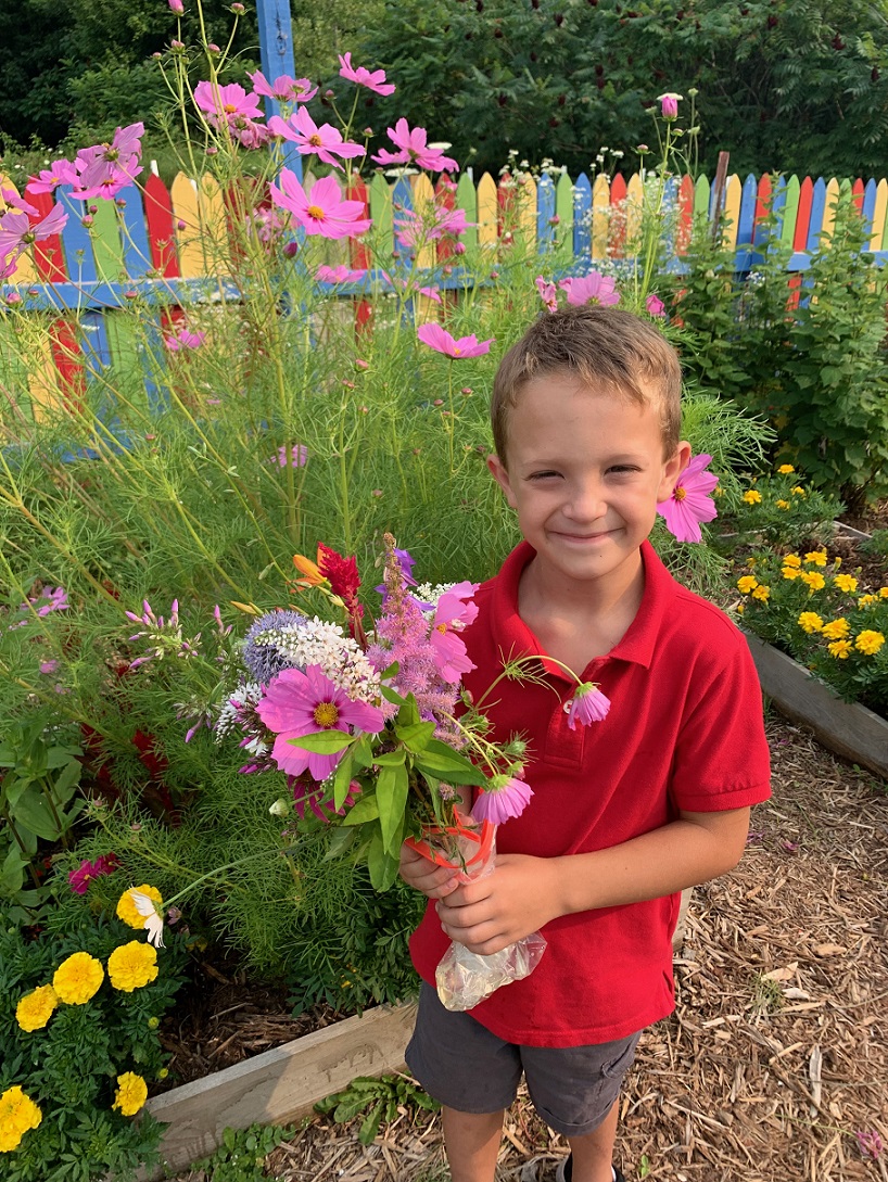 Kids Ranch Inc. youth holds flowers picked from a therapeutic garden